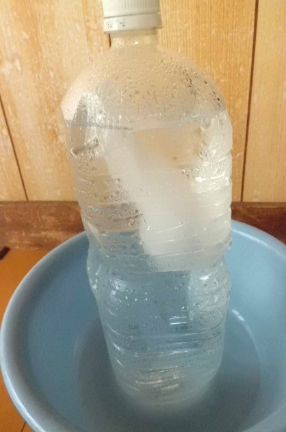 4時間後の凍った2リットルのペットボトル．上半分にだけ氷が残った状態